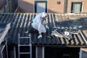 Man on a roof inspecting asbestos